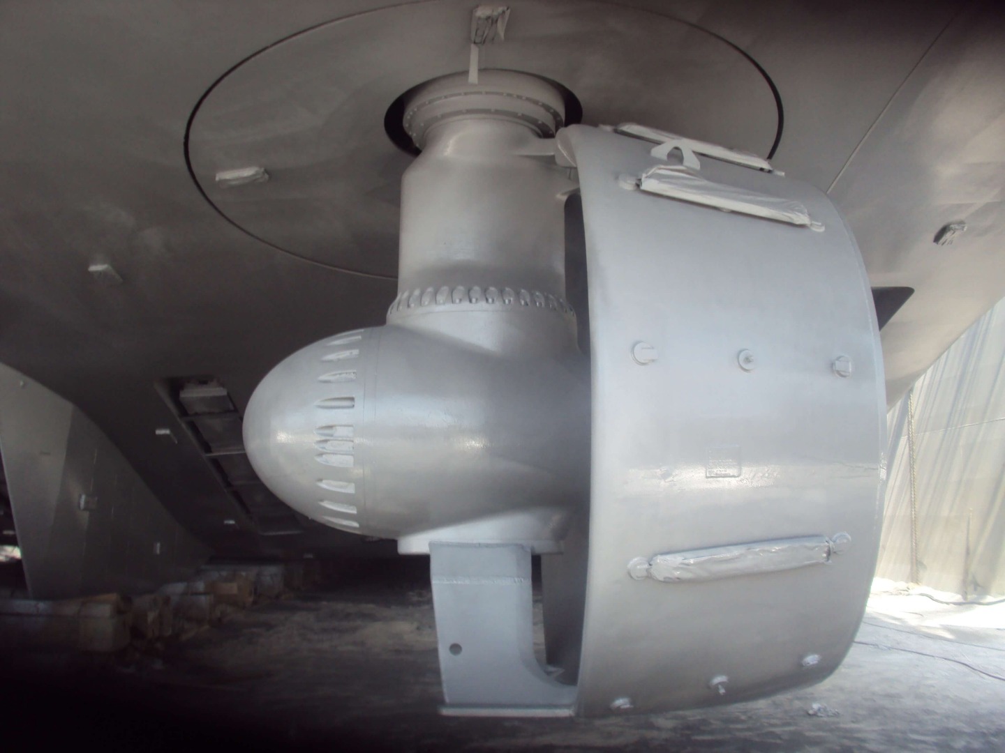 A marine vessel propeller and part of the hull are shown following application of a gray surface-tolerant mastic primer.