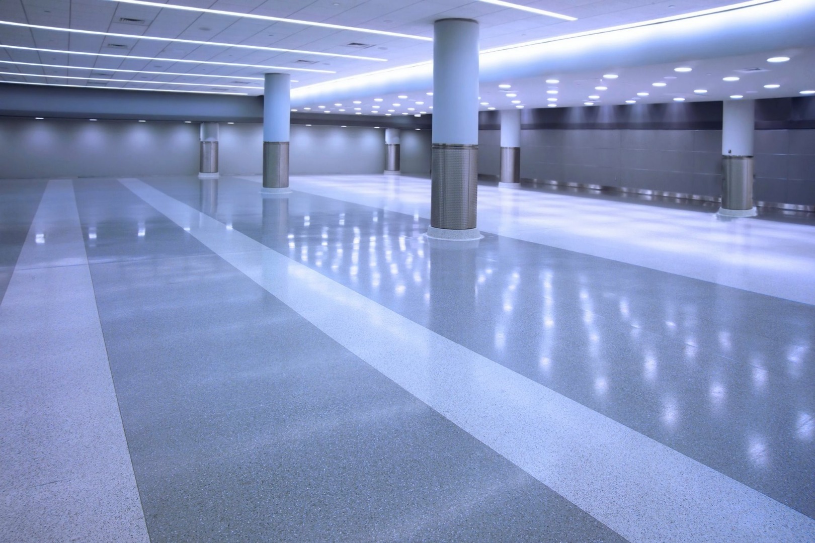 An empty server room with structural pylons and a semi-gloss coated floor.